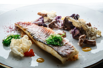 closeup trendy decorated delicious roasted fish fillet and vegetables