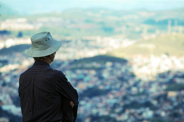 homem de chapéu olhando a cidade