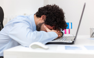 Tired businessman working in his office