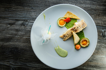 grilled white fish piece finely decorated with avocado and puree