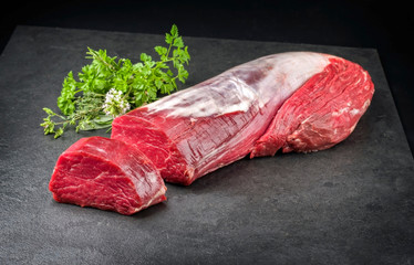 Dry aged beef fillet steak natural with a bouquet garni as closeup on black background with copy...