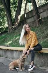 Obraz premium Young girl with dog walks in the park and enjoys the beautiful summer day.