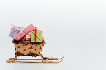 small and toy sleigh with colorful gifts isolated on white