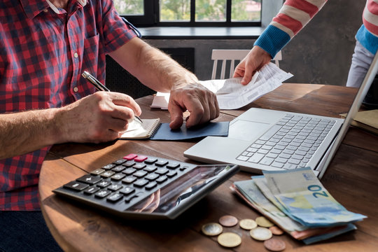 Man man checking home finance calculating money. No face view