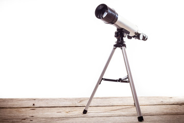telescope on a white background laid on wooden board