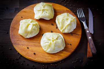 Manti, ravioli and Turkish cuisine dishes for the restaurant menu. Wooden background.