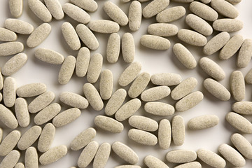 Large gray pills macro on white background, top view.