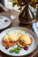 Pancakes with poached egg and smoked salmon. Served table for breakfast.