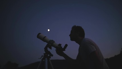 Astronomer with a telescope watching at the stars and Moon. My astronomy work.