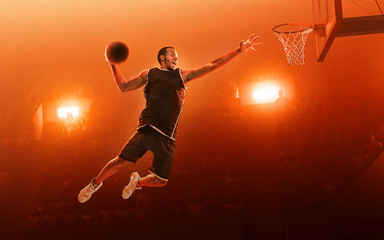 African american professional basketball player on basketball court in action with the ball. Slam...