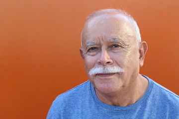 Senior Hispanic man in orange background 