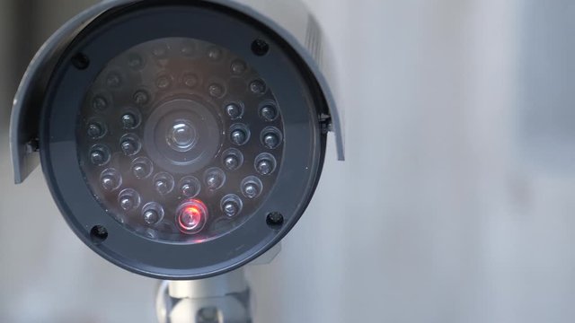 Security video camera moving to scan the area for surveillance purposes. Robotic CCTV recording technology.