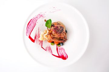 Grilled quail in a sauce with vegetables and berry confiture. Banquet festive dishes. Fine dining restaurant menu. White background.