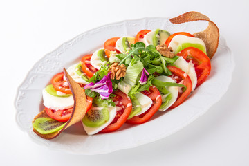 Snack made from fresh vegetables: tomatoes, mozza. Banquet festive dishes. Gourmet restaurant menu. White background.