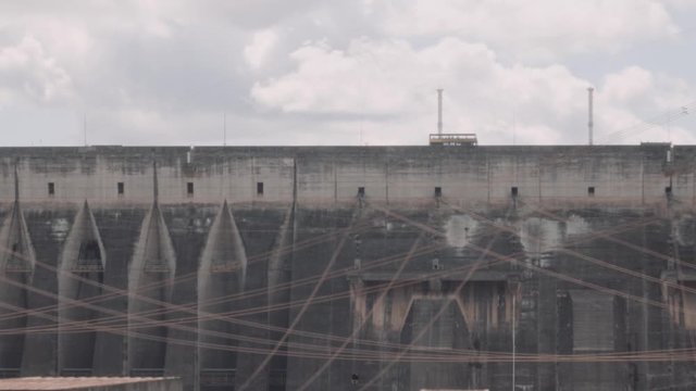 Tour bus on the road of the huge wall of the Hydro-Electric power station in the megastructure Itaipu dam, Foz do Iguacu, Brazil. 4k