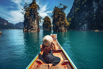 młoda kobieta turysta w azjatyckim kapeluszu na łodzi na jeziorze - 290625100