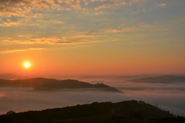 Fototapeta na wymiar sunset over mountains with fog in the valleys