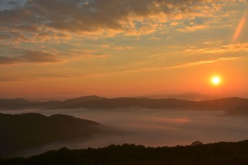 sunset over mountains with fog in the valleys