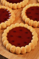 Raspberry jam tarts on wooden board 