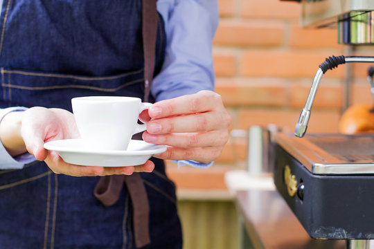 Mujer sostiene taza blanca de caf&eacute; al aire libre,  listo para probar