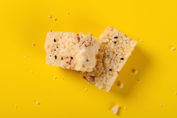top view traditional Chinese crisp rice block with peanuts on yellow background