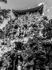Ancient chinese architecture with building on top of jagged stones with door in black and white
