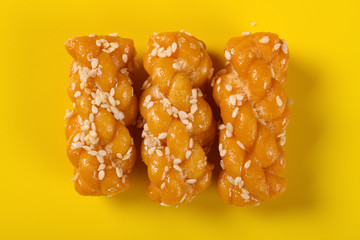 top view traditional Chinese twisted deep fried doughs on yellow background