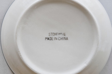 Bottom or base of a ceramic glazed dining bowl with the word 'Stoneware' to indicate type of...