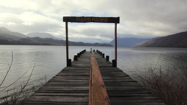 Peaceful dock over lake with sign, on cloudy day, Pucar&aacute;, Patagonia, Argentina