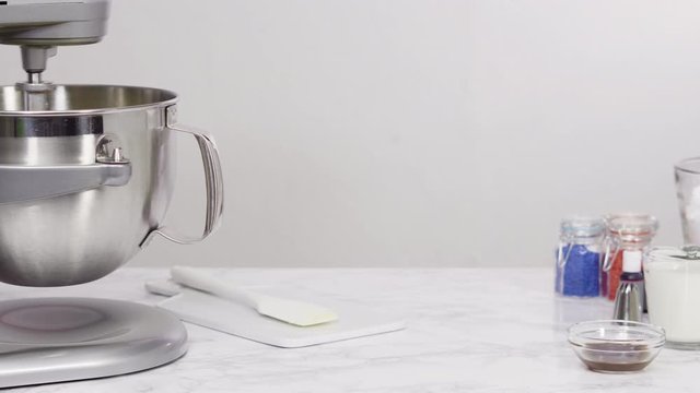 Step by step. Mixing ingredients in standing kitchen mixer to make buttercream frosting.