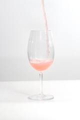 Serving rose wine on a white table and background
