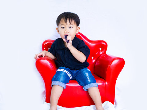 ฺBaby boy in black shait is eating delicious jelly