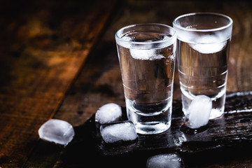 Cold cocktail with tonic, vodka and ice on the wooden background. World Vodka or Brandy Day