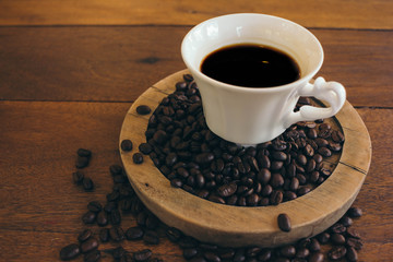 Black coffee in a white cup on a wooden table in cafe