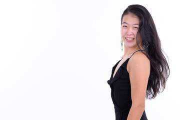 Profile view of happy beautiful Asian woman looking at camera ready to party