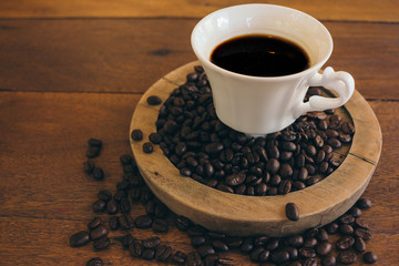 Black coffee in a white cup on a wooden table in cafe