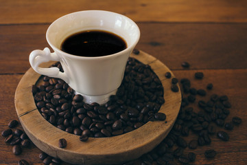 Black coffee in a white cup on a wooden table in cafe