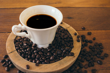 Black coffee in a white cup on a wooden table in cafe