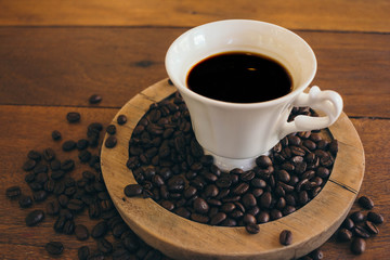 Black coffee in a white cup on a wooden table in cafe