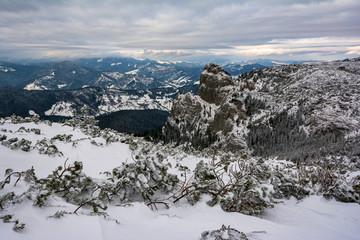 Fototapeta na wymiar Up in the mountain peak in winter with a little snow. Ceahlau Mountain, Romania