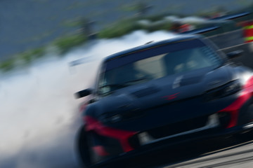 Obraz premium Motion blur close up drift car with smoke from burning tires