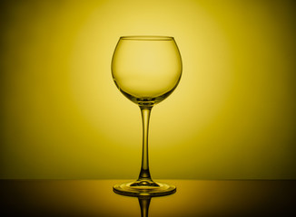Wine glass empty on colored light background