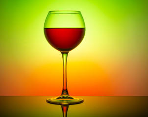 Wine glass with a drink on a colored light background