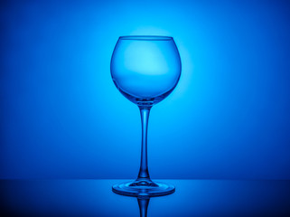 Wine glass empty on colored light background