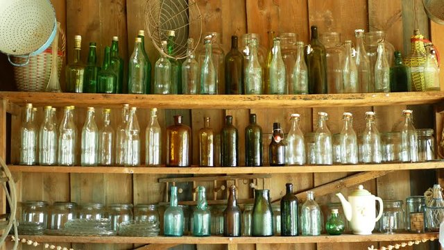 Jar bottles with glass and carboy, traditional Moravia cottage old folk Hana. Interior of peasant and dishes glassful hut, farmhouse, house articles furniture crockery or tumblerful punch things