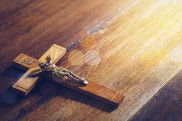 Obraz premium Close up of Jesus's crucifix on wooden table . Christian background trust and faith concept, copy space
