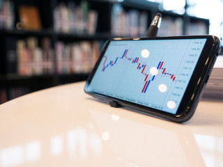 candle stick bar chart forex trading at working table with copyspace , business concept.