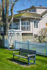 A bench outside of residential house front yard.