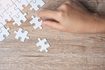 Businessman hand connecting  puzzle piece. Business solutions, mission target, successful, goals, cooperation, partnership and strategy concept