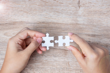 Businessman hand connecting couple puzzle piece. Business solutions, mission target, successful, goals, cooperation, partnership and strategy concept